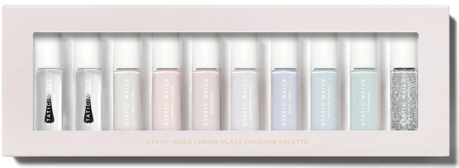 Static Nails Liquid Glass Lacquer Palette with ten mini nail polish bottles in sheer, pastel, and glitter shades arranged in a pale pink box.