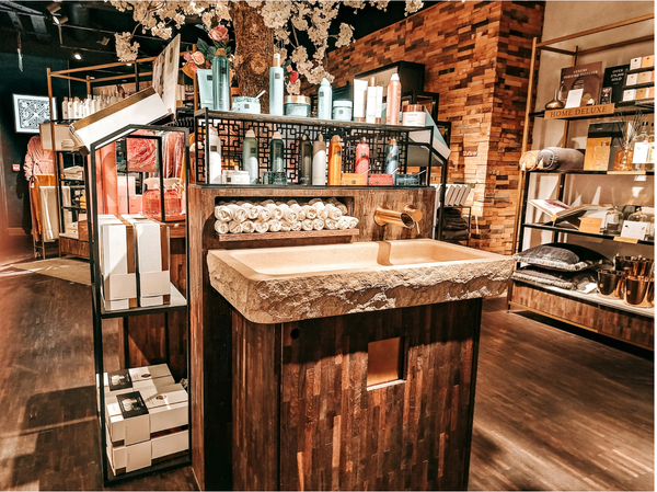 Image of store with shampoos, beauty products, a sink, towels and cleaners.